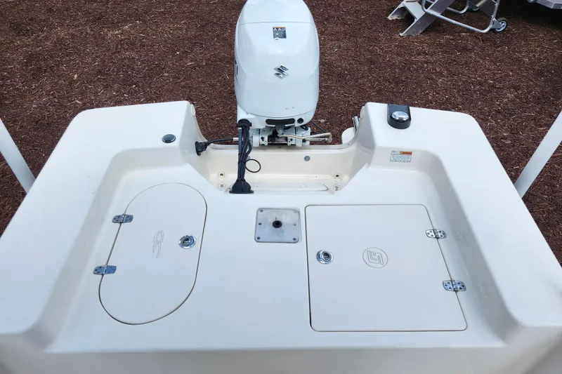 Slide: The Image of 2022 Carolina Skiff 178 JLS boat stern with outboard motor and storage compartments. - 24