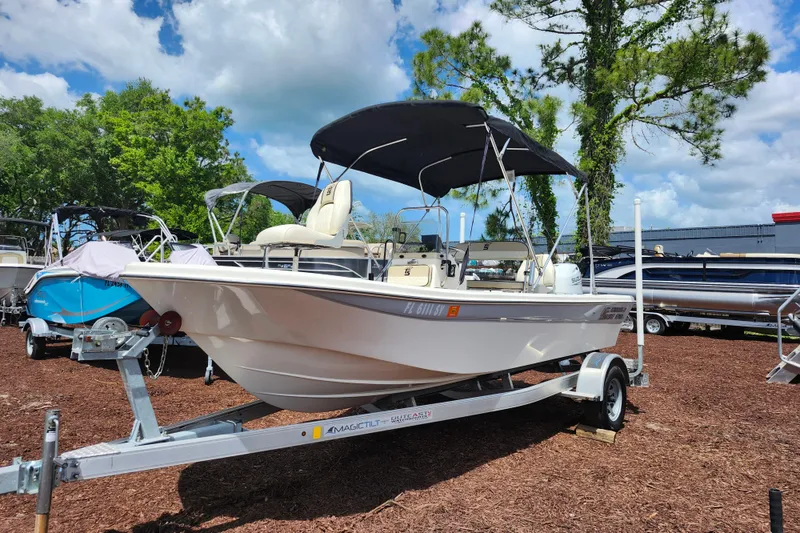 Slide: The Image of 2022 Carolina Skiff 178 JLS boat on trailer, parked outdoors under a blue sky. - 3