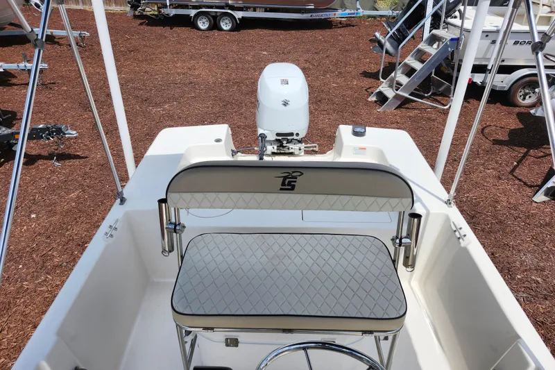Slide: The Image of 2022 Carolina Skiff 178 JLS boat interior with seating and motor, displayed outdoors. - 30