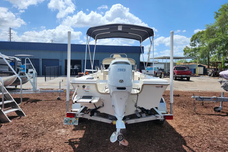 Slide: The Image of 2022 Carolina Skiff 178 JLS boat with outboard motor, parked outdoors under blue sky. - 6