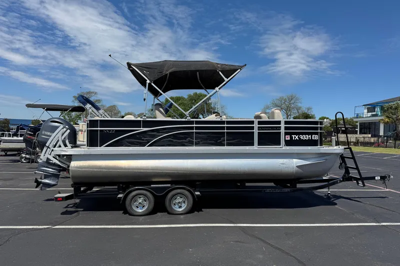 The Image of 2017 Bennington 22 SX Fish pontoon boat on trailer under clear sky. - 1