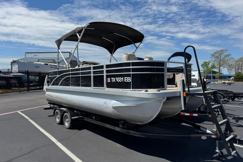 Slide: The Image of 2017 Bennington 22 SX Fish pontoon boat on trailer in parking lot. - 3