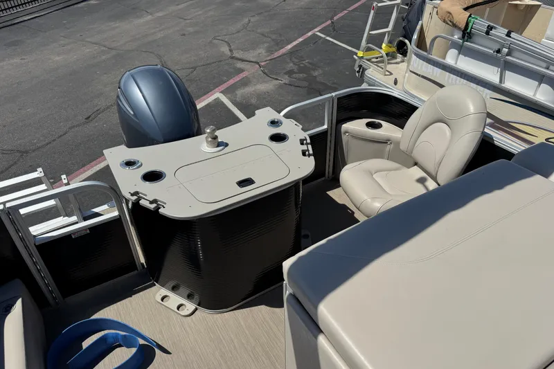 Slide: The Image of 2017 Bennington 22 SX Fish boat interior with seating and motor, parked on pavement. - 9