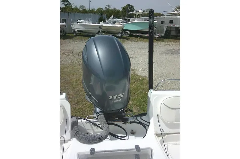 Slide: The Image of 2009 Carolina Skiff 198 DLV Elite with Yamaha 115 outboard motor in a boatyard. - 26