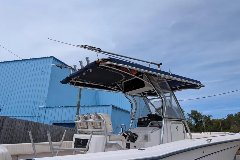 Slide: The Image of 2004 Grady-White Chase 273 boat with T-top and rod holders, docked near blue building. - 4