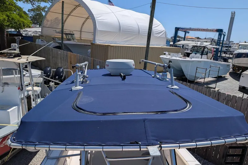 Slide: The Image of 2004 Grady-White Chase 273 boat with blue canopy at a marina. - 6