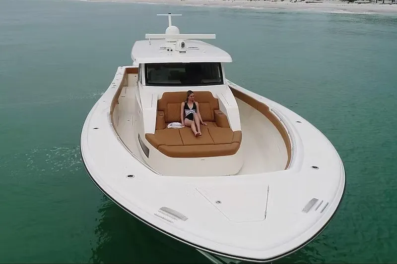 Slide: The Image of Manufacturer Provided Image: 2026 Ocean Yachts 52 CC cruising on clear waters with a person relaxing on deck. - 4