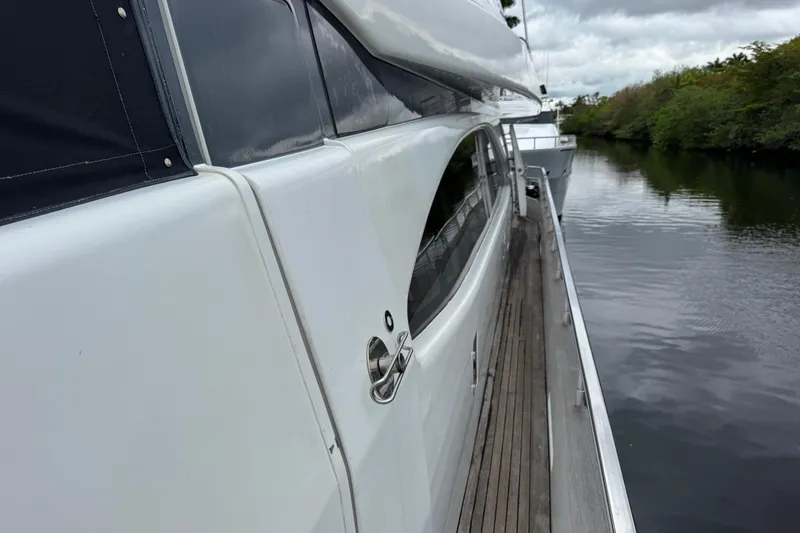 Slide: The Image of Side view of a 1998 Azimut 85 Ultimate yacht docked by a calm river. - 11