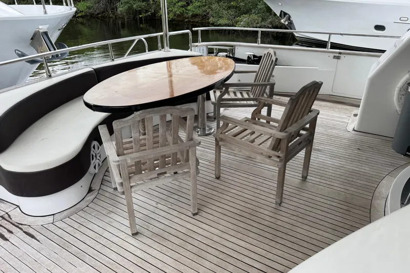 Slide: The Image of Deck seating area on 1998 Azimut 85 Ultimate yacht with wooden chairs and table. - 3