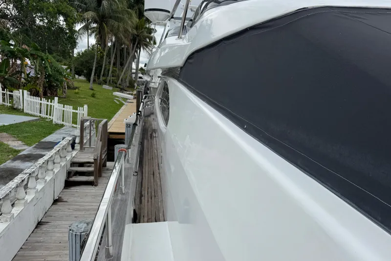 Slide: The Image of Side view of a 1998 Azimut 85 Ultimate yacht docked near a tropical landscape. - 6