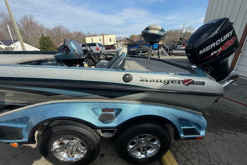 Slide: The Image of 2013 Ranger Z520C Carbon Comanche boat with Mercury Pro XS engine, parked outdoors. - 1