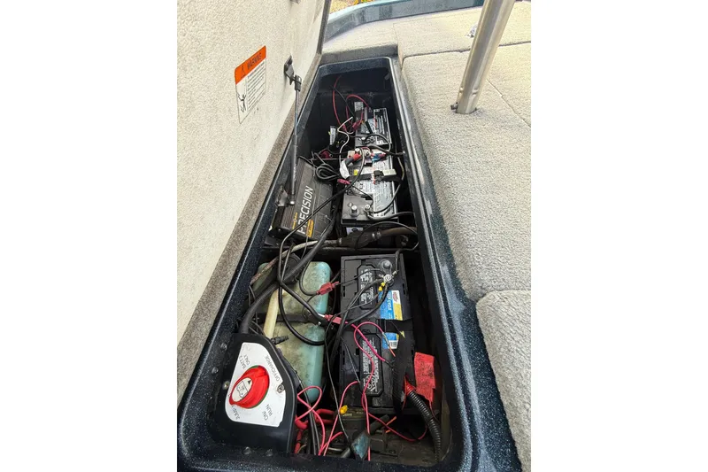 Slide: The Image of 2013 Ranger Z520C Carbon Comanche boat battery compartment with wiring and charger. - 23