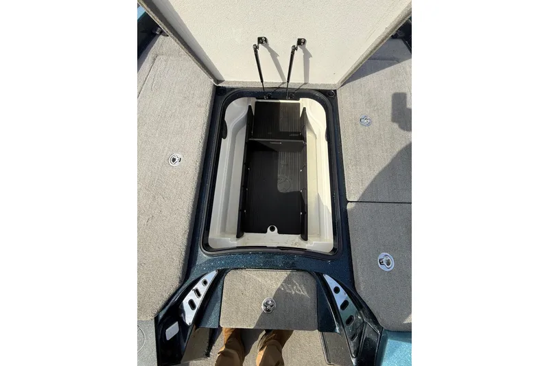 Slide: The Image of 2013 Ranger Z520C Carbon Comanche boat storage compartment with open lid and carpeted deck. - 29