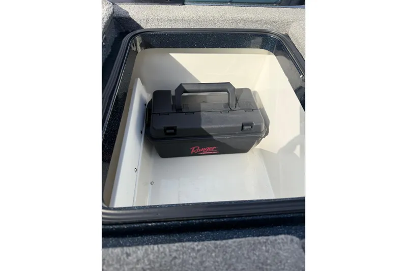Slide: The Image of Storage compartment with a black toolbox inside a 2013 Ranger Z520C Carbon Comanche boat. - 41