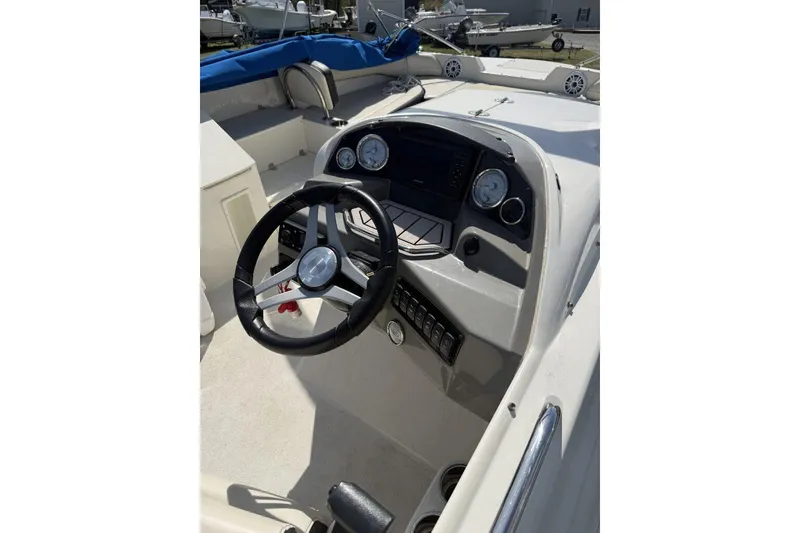 Slide: The Image of 2021 Stingray 212 SC boat dashboard with steering wheel and control panel. - 11