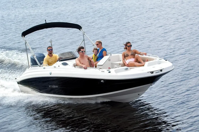 Slide: The Image of 2021 Stingray 212 SC boat cruising with passengers on a sunny day. - 16