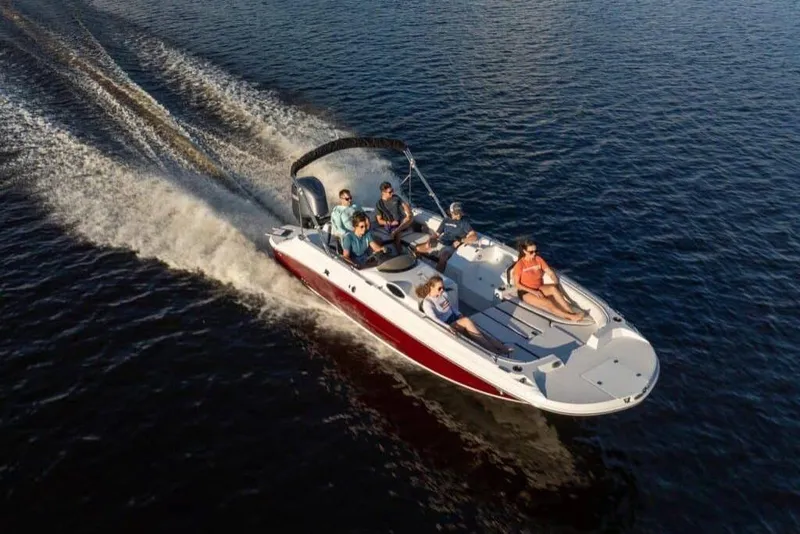 Slide: The Image of 2021 Stingray 212 SC boat cruising on open water with passengers enjoying the ride. - 17