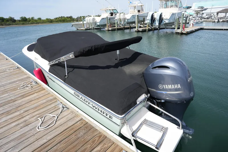 Slide: The Image of 2017 Grady-White Freedom 205 boat docked with Yamaha engine, covered in black tarp. - 11