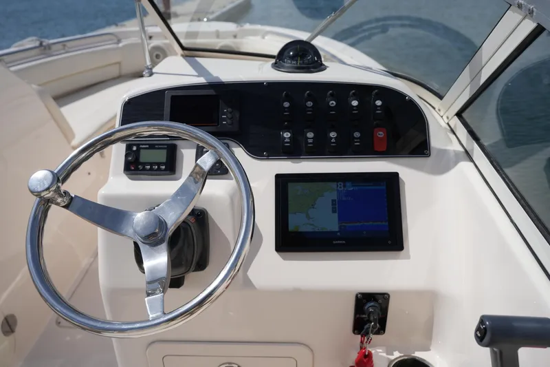 Slide: The Image of 2017 Grady-White Freedom 205 boat dashboard with steering wheel and navigation controls. - 19
