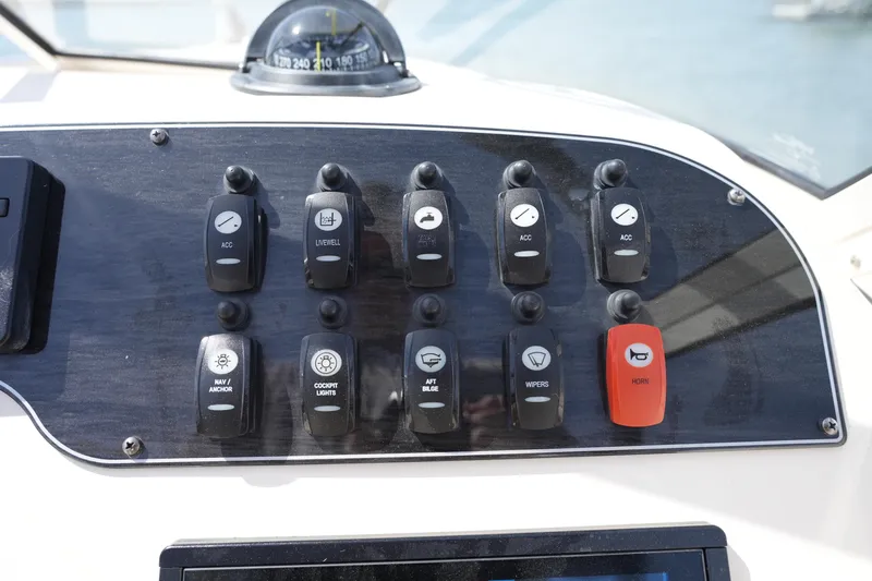 Slide: The Image of Control panel of a 2017 Grady-White Freedom 205 boat with various switches. - 22