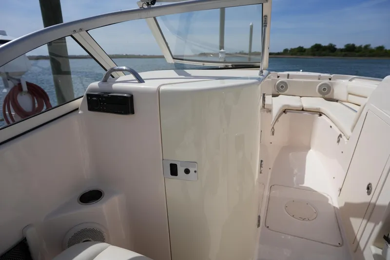 Slide: The Image of 2017 Grady-White Freedom 205 boat interior with seating and control panel, docked by the water. - 25