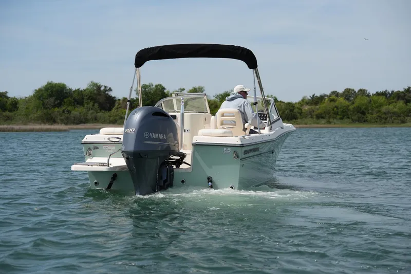 Slide: The Image of 2017 Grady-White Freedom 205 boat cruising on a serene lake with lush greenery. - 5