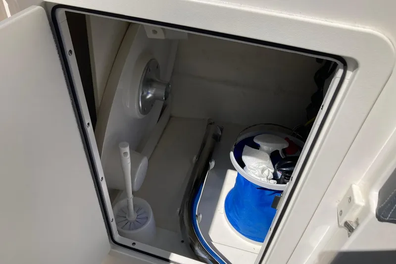 Slide: The Image of Storage compartment on a 2022 Chaparral 267 SSX OB boat with cleaning supplies. - 10