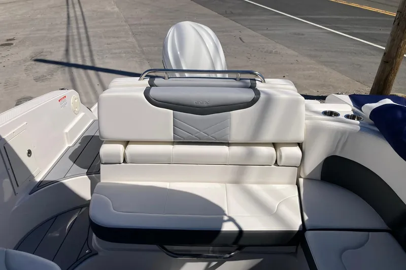 Slide: The Image of 2022 Chaparral 267 SSX OB boat interior with white cushioned seating and sleek design. - 11
