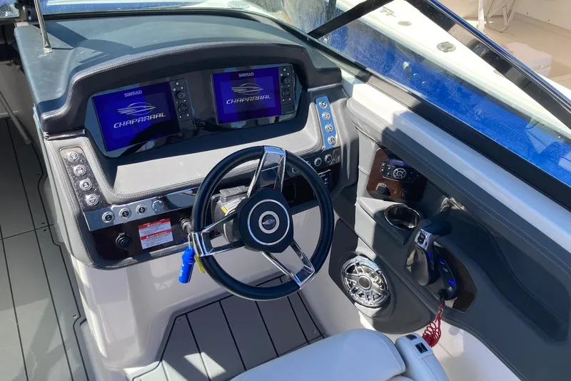 Slide: The Image of 2022 Chaparral 267 SSX OB boat dashboard with steering wheel and control panels. - 12