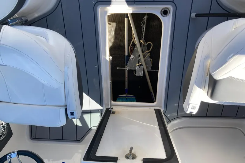 Slide: The Image of 2022 Chaparral 267 SSX OB boat interior storage compartment with white seating. - 13