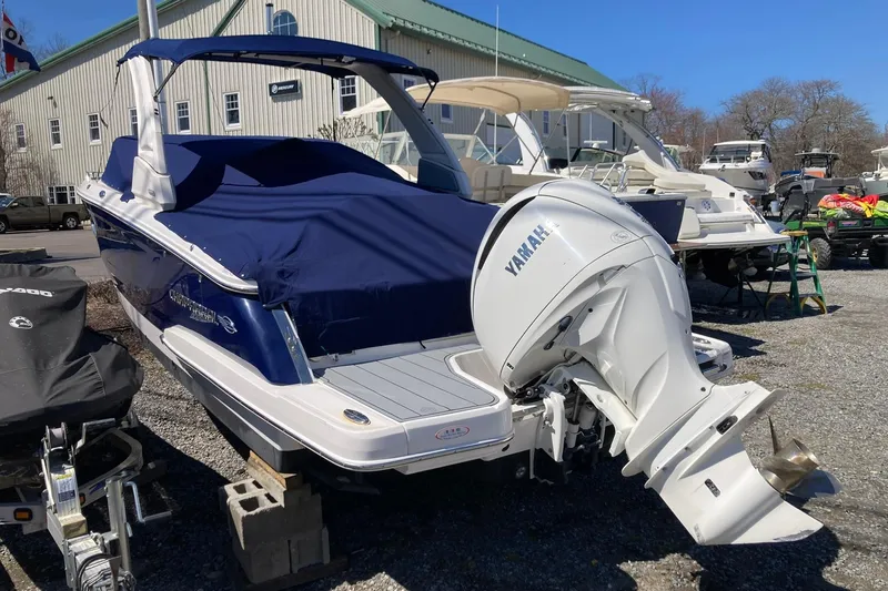 Slide: The Image of 2022 Chaparral 267 SSX OB boat with Yamaha outboard engine, covered and parked outdoors. - 2