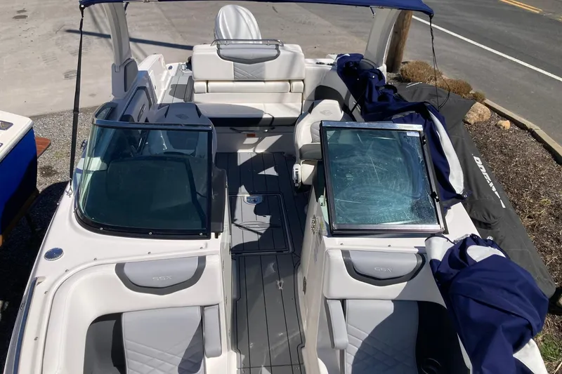 Slide: The Image of 2022 Chaparral 267 SSX OB boat interior with seating and windshield, docked outdoors. - 21