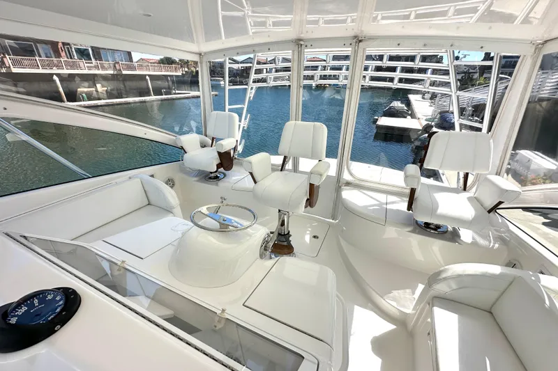 Slide: The Image of Luxurious interior of a 2012 Viking 42 Open yacht with white seating and panoramic windows. - 11