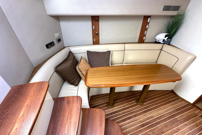 Slide: The Image of Interior of 2012 Viking 42 Open yacht with wooden table and cushioned seating. - 22