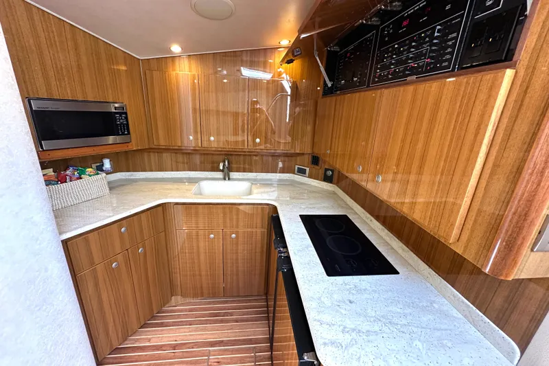 Slide: The Image of Luxurious 2012 Viking 42 Open yacht kitchen with wood cabinetry and modern appliances. - 23