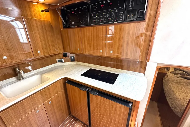 Slide: The Image of Luxurious 2012 Viking 42 Open yacht kitchen with wood cabinetry and modern appliances. - 25