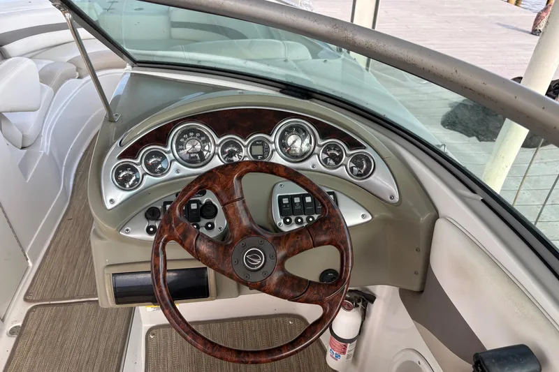 Slide: The Image of 2007 Crownline 252 EX boat dashboard with wood-grain steering wheel and instrument panel. - 11
