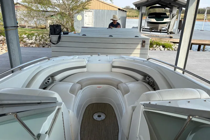 Slide: The Image of 2007 Crownline 252 EX boat with white seating, docked near a wooden pier. - 12