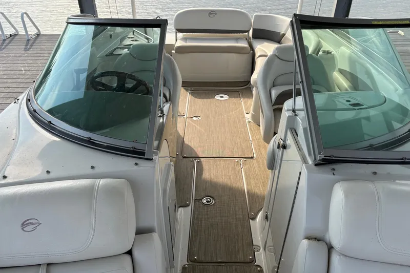 Slide: The Image of 2007 Crownline 252 EX boat interior with seating and steering wheel, docked by the water. - 15