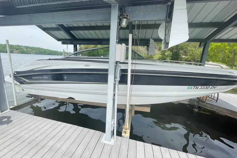 Slide: The Image of 2007 Crownline 252 EX boat docked under a covered structure on a lake. - 3