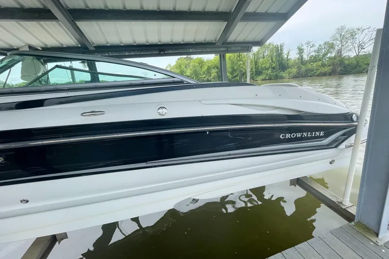 Slide: The Image of 2007 Crownline 252 EX boat docked under a covered structure by the water. - 5