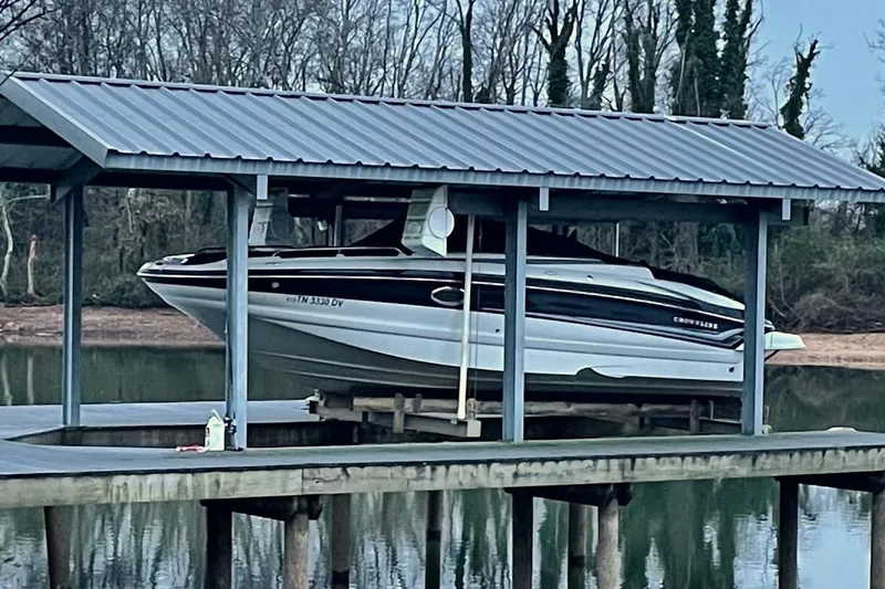 Slide: The Image of 2007 Crownline 252 EX boat docked under a metal roof by a lake. - 6