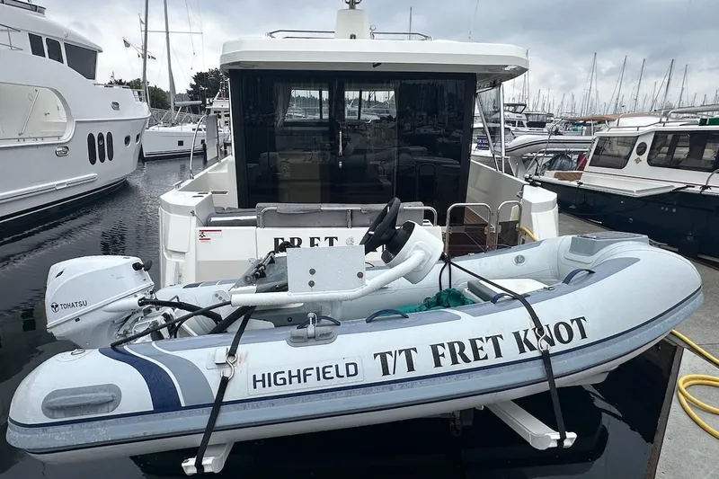 Slide: The Image of 2024 Beneteau Swift Trawler 41 Sedan with Highfield tender docked at marina. - 14