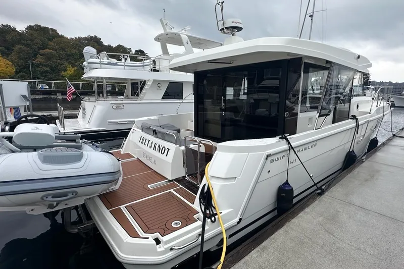 Slide: The Image of 2024 Beneteau Swift Trawler 41 Sedan docked, showcasing sleek design and spacious deck. - 19