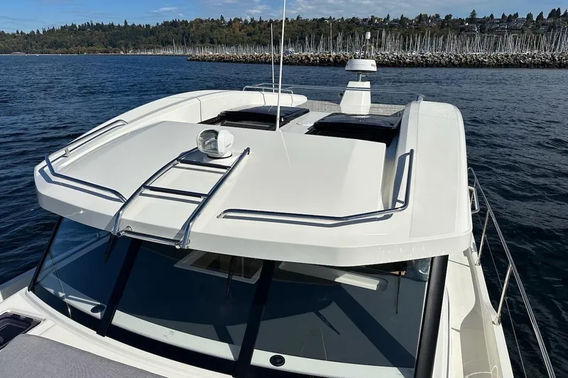 Slide: The Image of 2024 Beneteau Swift Trawler 41 Sedan on water, showcasing sleek design and rooftop features. - 34