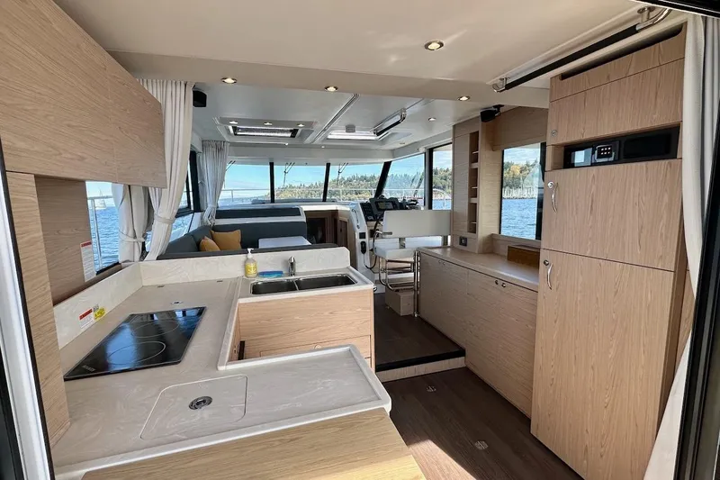 Slide: The Image of 2024 Beneteau Swift Trawler 41 Sedan interior with modern kitchen and panoramic windows. - 40