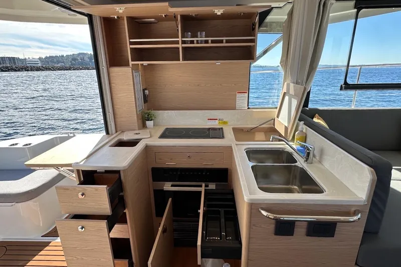 Slide: The Image of 2024 Beneteau Swift Trawler 41 Sedan kitchen with modern amenities and ocean view. - 42