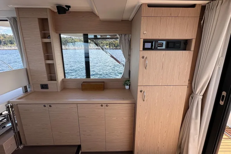Slide: The Image of Interior of 2024 Beneteau Swift Trawler 41 Sedan with wood cabinetry and scenic window view. - 44