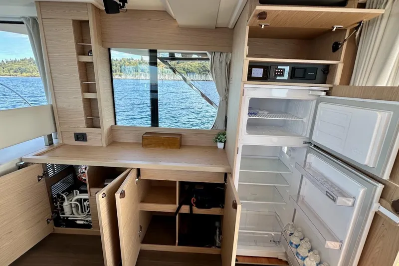 Slide: The Image of Interior of 2024 Beneteau Swift Trawler 41 Sedan with open cabinets and refrigerator. - 45