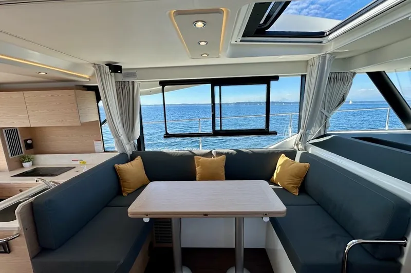 Slide: The Image of Interior of 2024 Beneteau Swift Trawler 41 Sedan with ocean view and cozy seating area. - 49